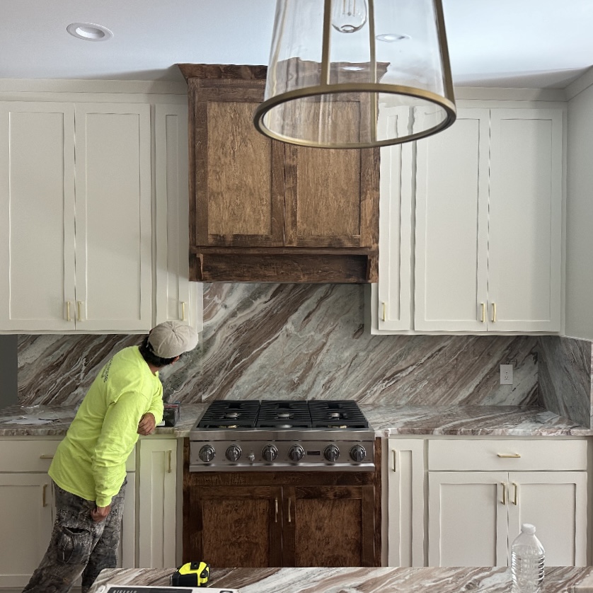Worker installing custom cabinetry in modern kitchen