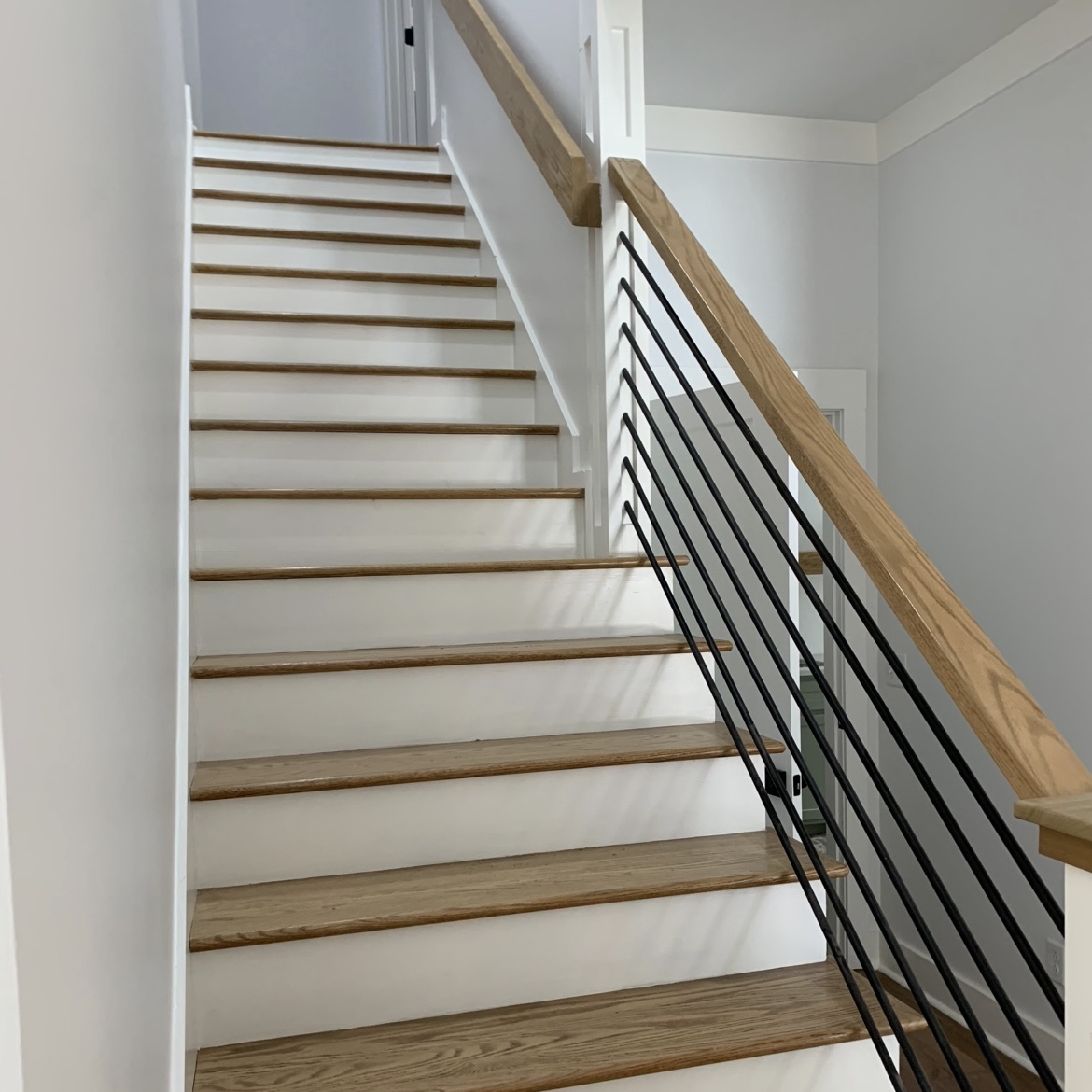 Finished wood stairs with modern black rail spindles
