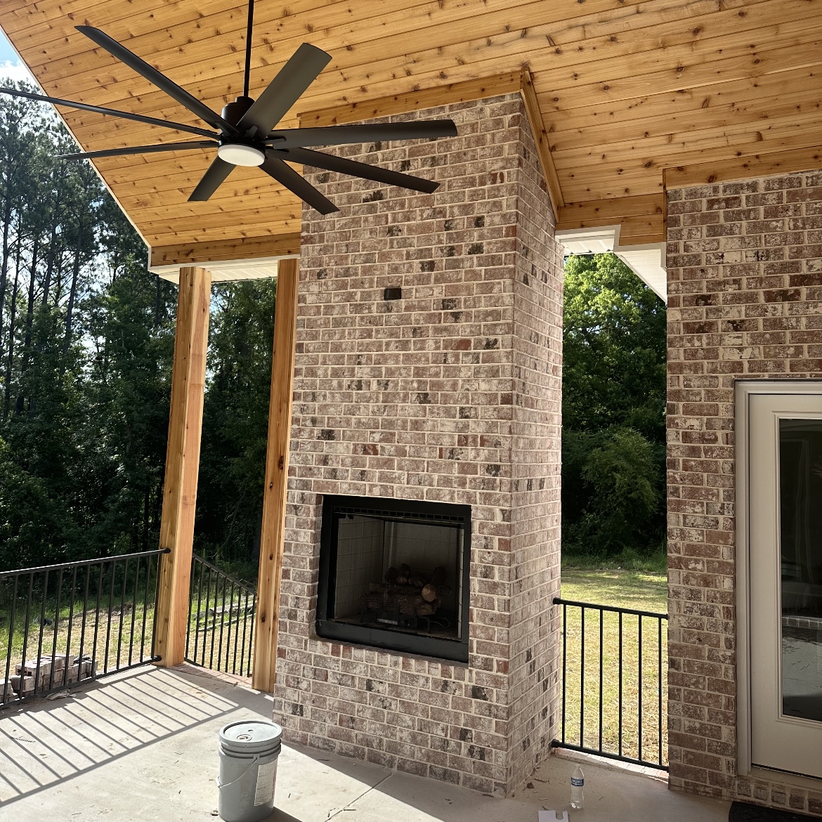 Covered patio with brick fireplace and ceiling fan