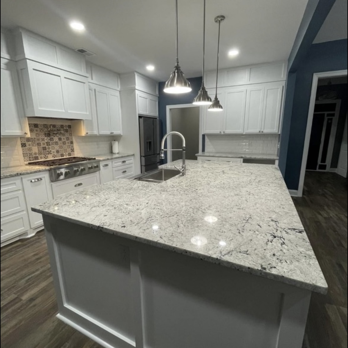 Bright kitchen with granite island and pendant lighting